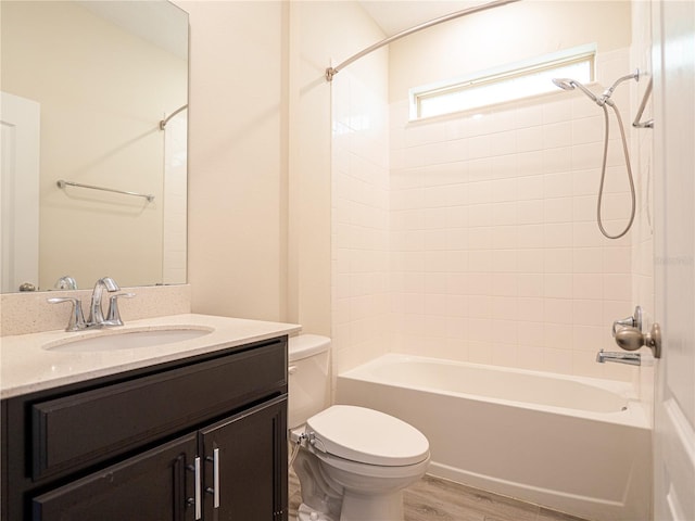 full bathroom with vanity, toilet, hardwood / wood-style flooring, and tiled shower / bath combo