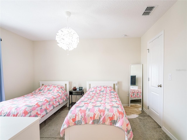 carpeted bedroom with a textured ceiling and an inviting chandelier