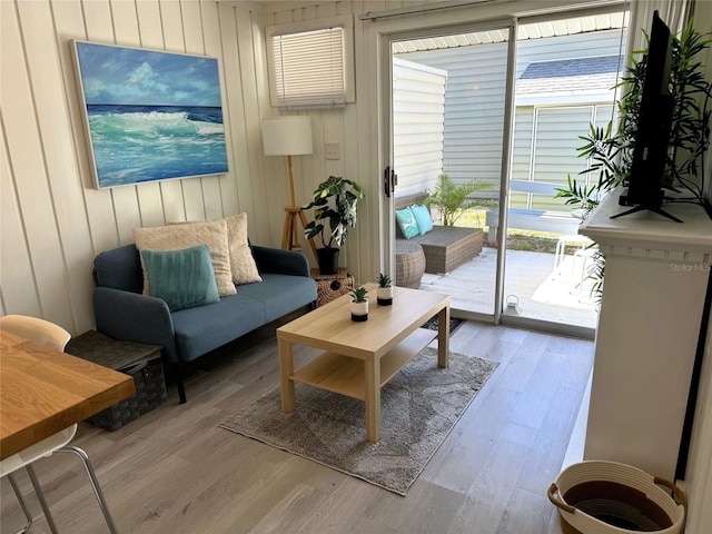 living area featuring light hardwood / wood-style floors and wood walls