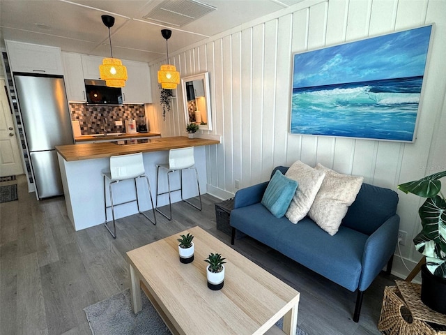 living room with wood walls and dark hardwood / wood-style flooring