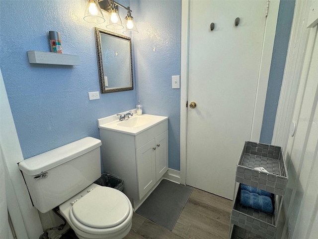 bathroom with vanity, wood-type flooring, and toilet