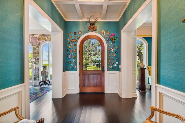 foyer with beamed ceiling, coffered ceiling, ornamental molding, and dark hardwood / wood-style flooring