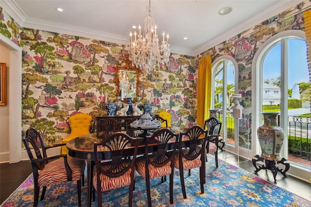 dining area featuring wood-type flooring, ornamental molding, and an inviting chandelier