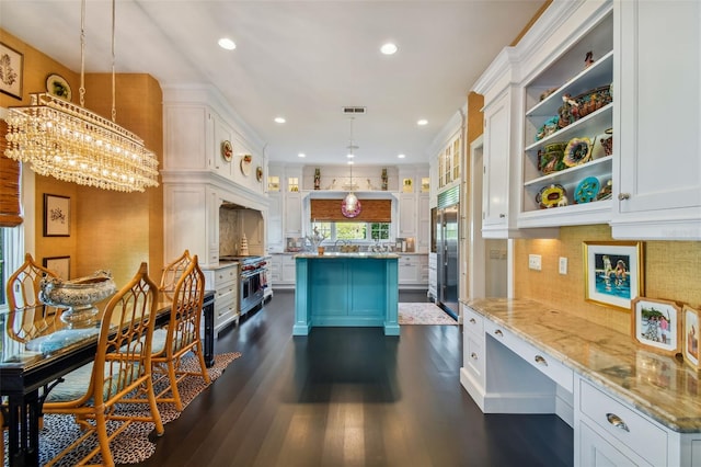 kitchen featuring high end appliances, dark wood-type flooring, white cabinets, and decorative light fixtures