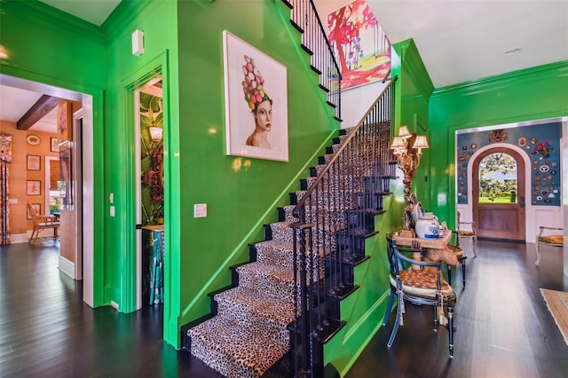 interior space with beamed ceiling, ornamental molding, and dark hardwood / wood-style flooring