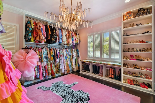 walk in closet featuring a notable chandelier