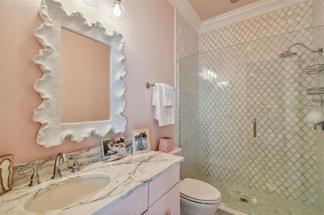 bathroom featuring toilet, ornamental molding, vanity, and a shower with door