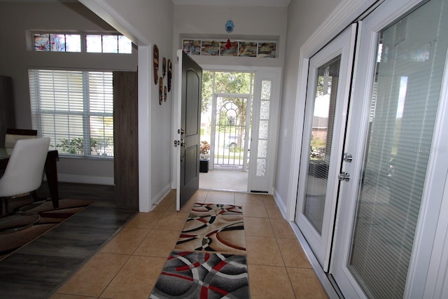 doorway to outside with french doors, a healthy amount of sunlight, and light tile patterned floors