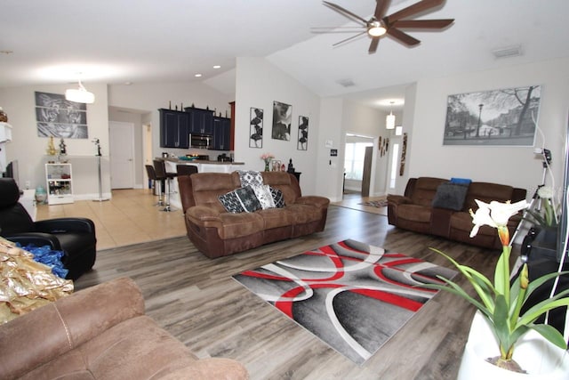 living room with lofted ceiling, wood-type flooring, and ceiling fan