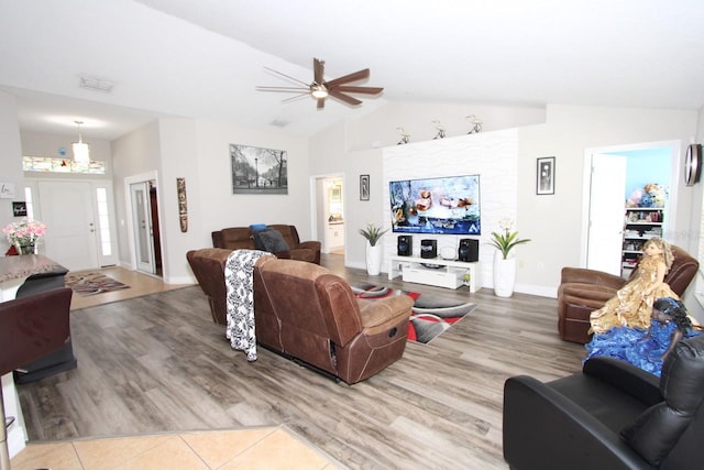 living room with ceiling fan, wood-type flooring, and vaulted ceiling