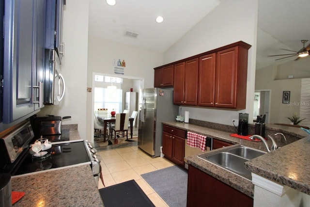 kitchen featuring light tile patterned flooring, stainless steel appliances, sink, and vaulted ceiling