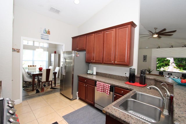 kitchen with lofted ceiling, ceiling fan, light tile patterned floors, stainless steel appliances, and sink