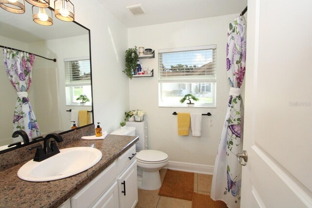 bathroom with toilet, tile patterned floors, a shower with curtain, vanity, and a notable chandelier