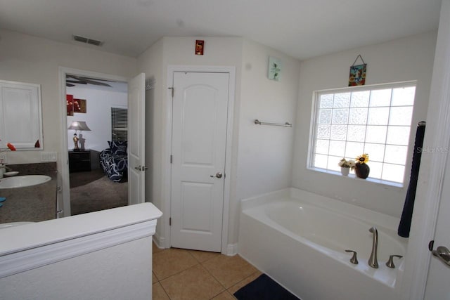 bathroom featuring vanity, tile patterned floors, and a washtub