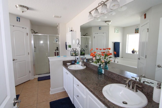 bathroom featuring vanity, a textured ceiling, shower with separate bathtub, and tile patterned floors