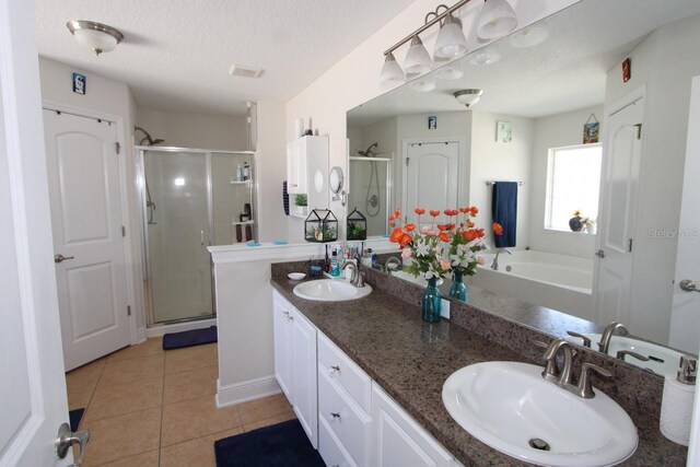1545 Blue Sky Blvd, Haines City, FL 33844 - full bathroom with a stall shower, tile patterned flooring, double vanity, a textured ceiling, and a tub