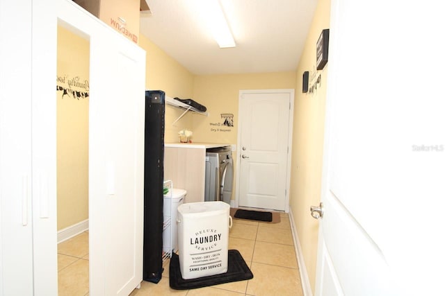 washroom with independent washer and dryer and light tile patterned floors