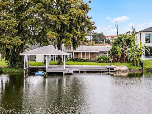 view of dock with a yard and a water view