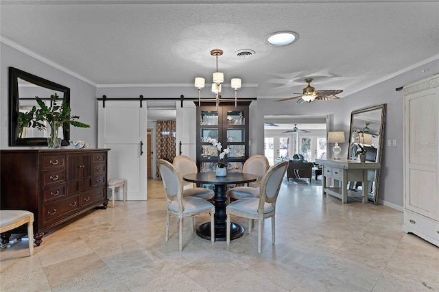 dining space with ornamental molding, a barn door, a textured ceiling, and ceiling fan with notable chandelier