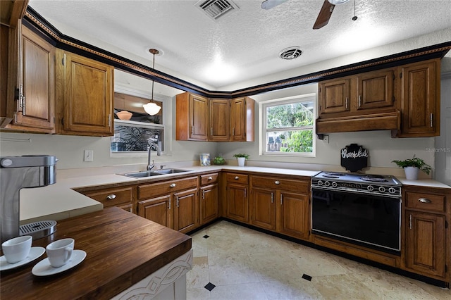 kitchen featuring electric range oven, hanging light fixtures, sink, a textured ceiling, and ceiling fan