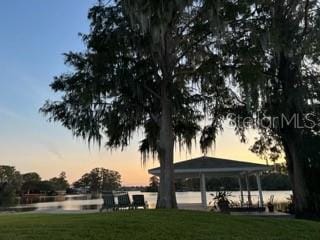 view of home's community with a gazebo, a water view, and a lawn