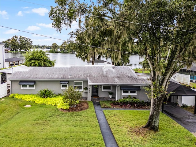 ranch-style house featuring a water view and a front lawn