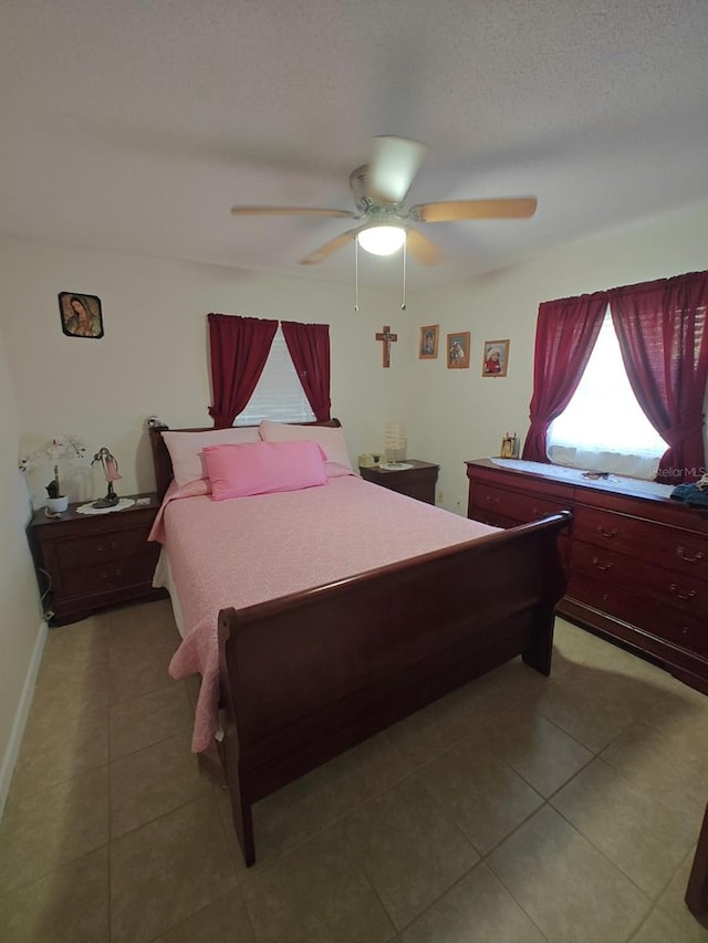 tiled bedroom featuring ceiling fan