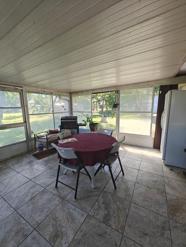 unfurnished sunroom featuring a wealth of natural light and wood ceiling