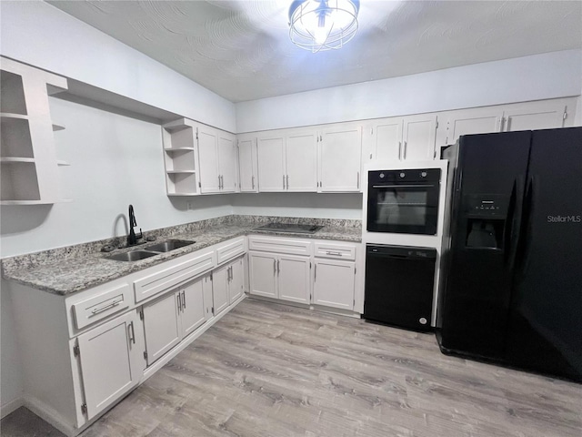 kitchen featuring light stone countertops, sink, light hardwood / wood-style floors, white cabinets, and black appliances