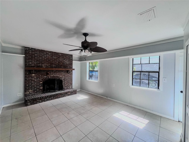 unfurnished living room with light tile patterned floors, a brick fireplace, ceiling fan, and ornamental molding