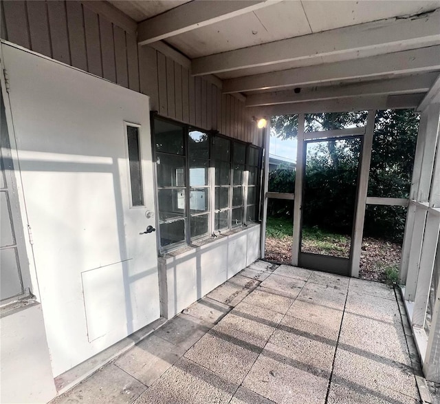 unfurnished sunroom with beam ceiling