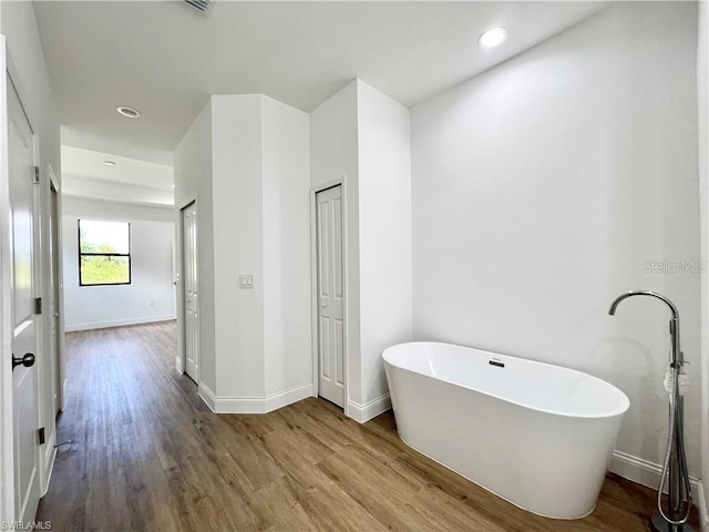 bathroom with wood-type flooring and a washtub