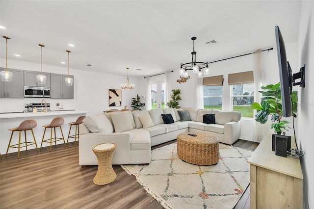 living room featuring a notable chandelier and light wood-type flooring