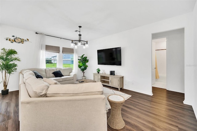 living room with a notable chandelier and dark hardwood / wood-style flooring