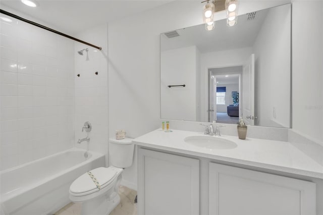 full bathroom featuring vanity, tiled shower / bath, and toilet