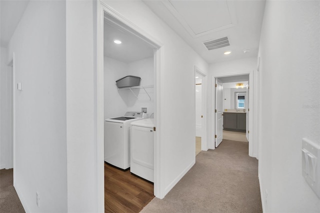 hallway featuring washing machine and dryer and dark colored carpet