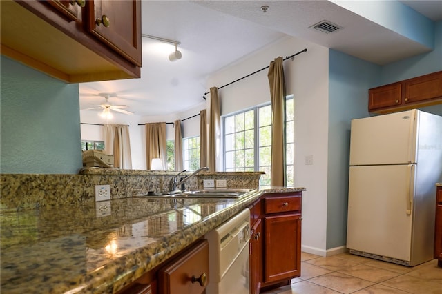 kitchen with white appliances, ceiling fan, sink, stone countertops, and light tile patterned flooring