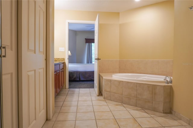 bathroom featuring vanity, a relaxing tiled tub, and tile patterned floors