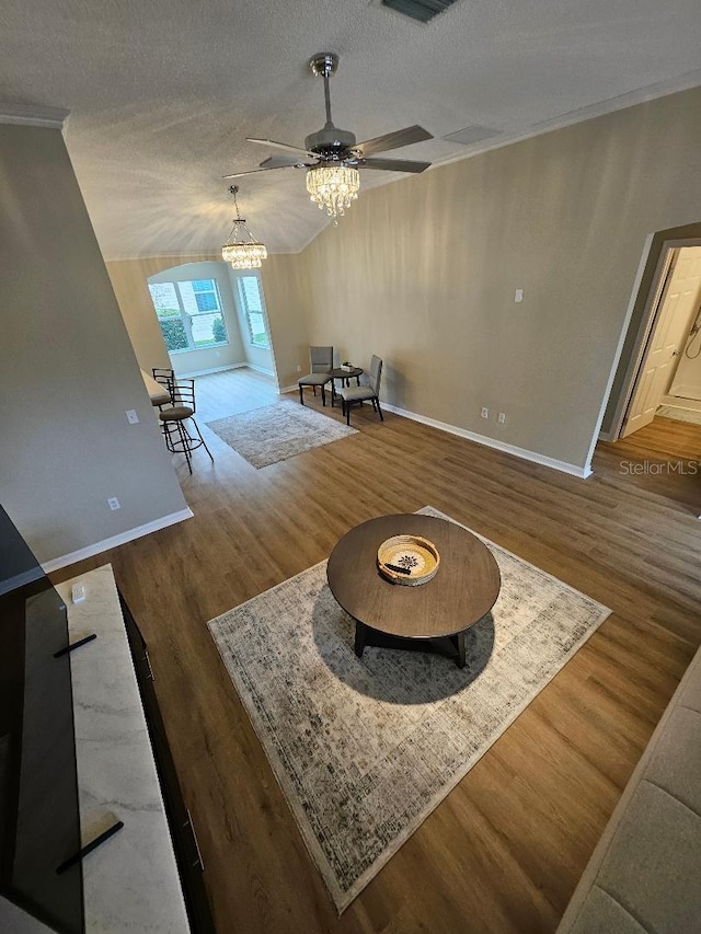 living room featuring a textured ceiling, ceiling fan with notable chandelier, and dark wood-type flooring