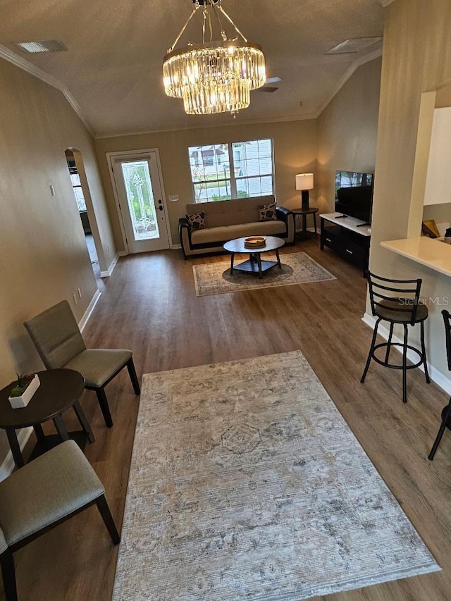 living room with a textured ceiling, dark hardwood / wood-style floors, crown molding, and lofted ceiling