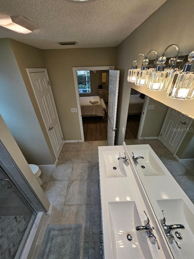 bathroom with vanity, toilet, and a textured ceiling