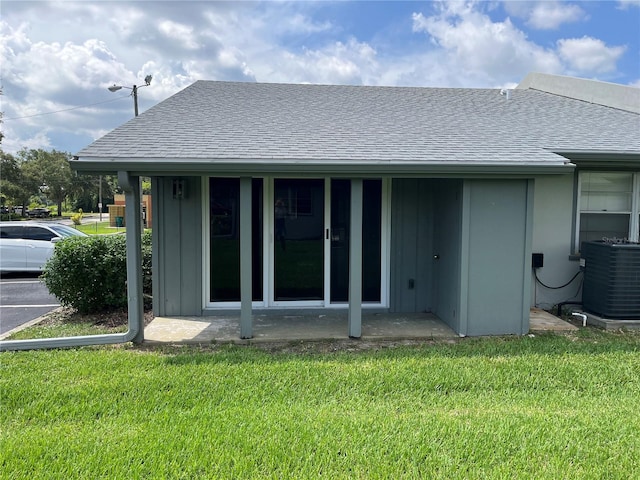 back of property featuring a yard and central air condition unit