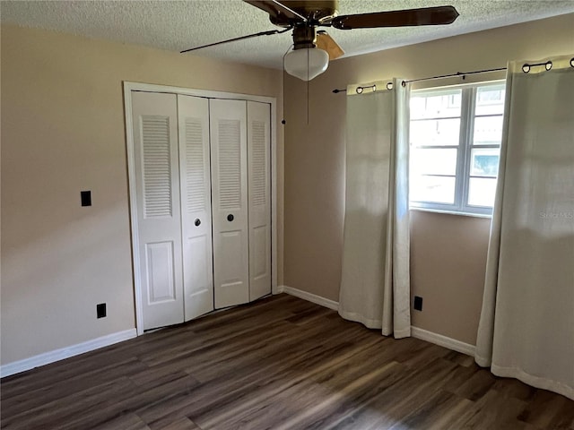 unfurnished bedroom featuring a closet, a textured ceiling, dark wood-type flooring, and ceiling fan