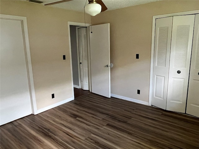 unfurnished bedroom featuring a closet, a textured ceiling, ceiling fan, and dark hardwood / wood-style flooring