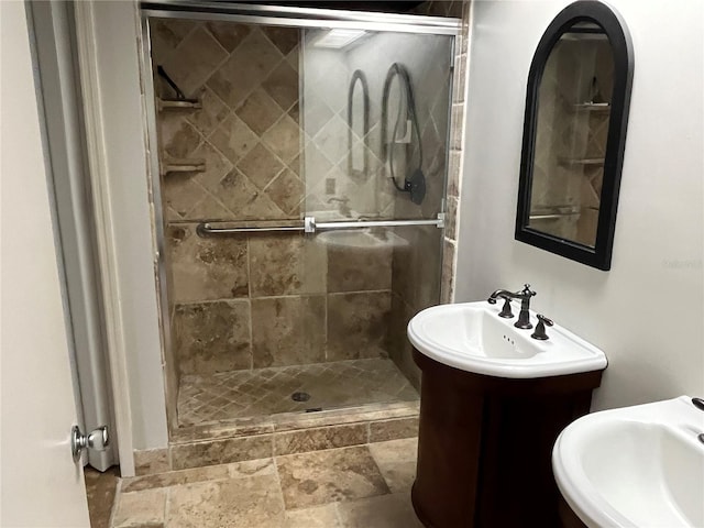 bathroom featuring a shower with door and vanity