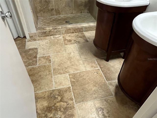 bathroom featuring a tile shower and vanity