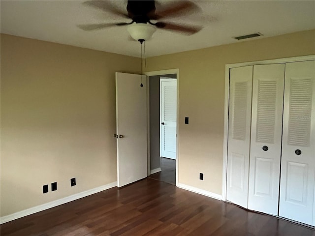 unfurnished bedroom with a closet, ceiling fan, and dark hardwood / wood-style flooring