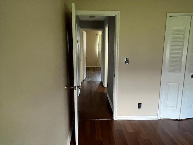 corridor with dark hardwood / wood-style flooring