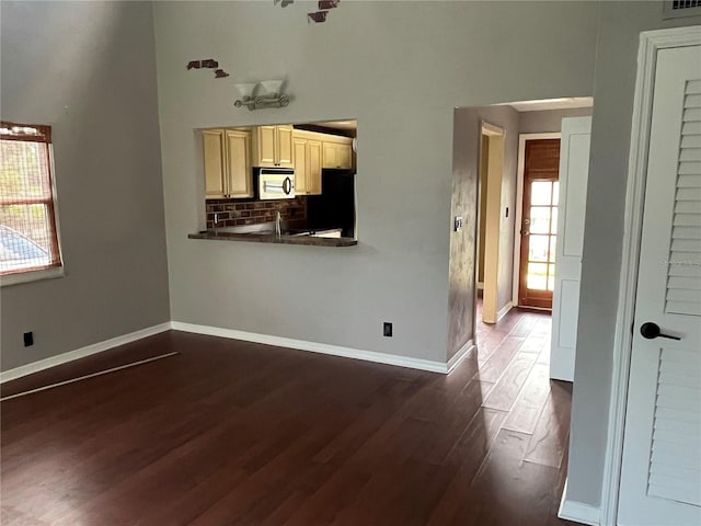 unfurnished living room with a wealth of natural light and dark hardwood / wood-style flooring