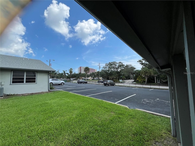 view of parking with a yard